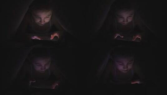 小女孩晚上在手机上玩游戏高清在线视频素材下载
