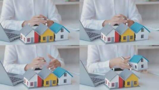 人手持笔在电脑旁查看房屋模型高清在线视频素材下载