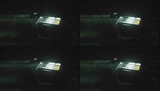 夜晚雪花中汽车前灯的特写镜头高清在线视频素材下载