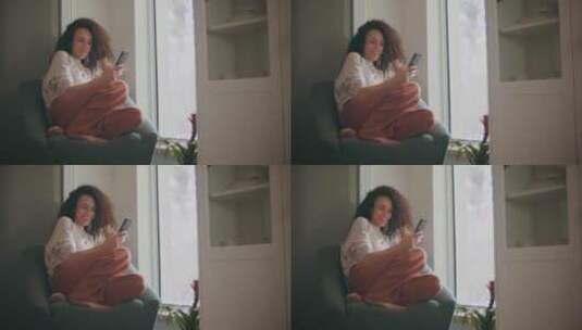女人在家看着手机微笑高清在线视频素材下载