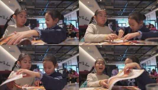 在餐厅翻阅菜单点餐的两个亚洲女孩高清在线视频素材下载