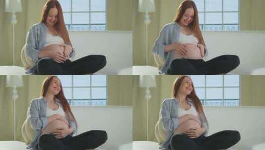 怀孕母亲人们期待未来孕妇触摸大肚子坐在沙高清在线视频素材下载