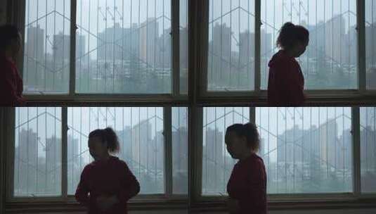 室内窗边中年女性双手抱腹高清在线视频素材下载