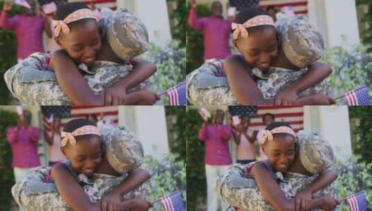 非裔美国士兵父亲拥抱微笑的女儿，背后有家人和美国国旗高清在线视频素材下载