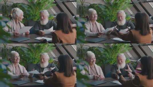 老年白人夫妇在咖啡馆与女代理人签署保险单高清在线视频素材下载