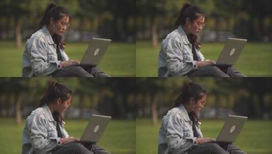 一位女大学生坐在校园草地上用笔记本电脑高清在线视频素材下载