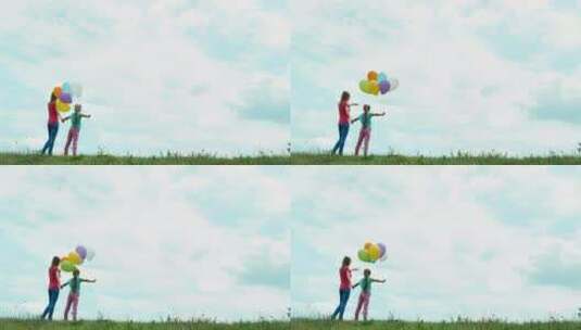母女拿气球站在草地上高清在线视频素材下载