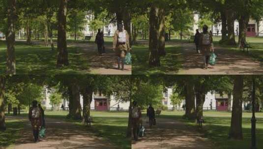 游客在公园树下行走的镜头高清在线视频素材下载