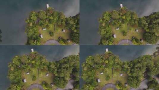 移动无人机视频俯瞰火山口湖旁边郁郁葱葱的公园区域，云层回流高清在线视频素材下载