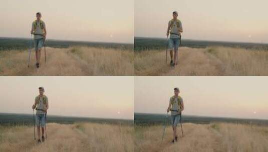 一个年轻的成年男子背着背包独自走在田野里高清在线视频素材下载