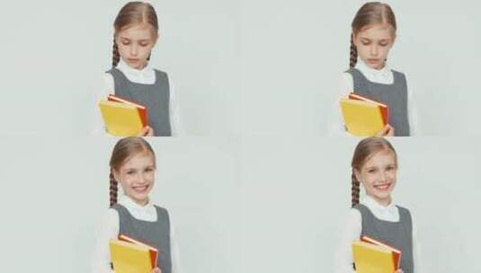 在白色背景前拿书籍的女生高清在线视频素材下载