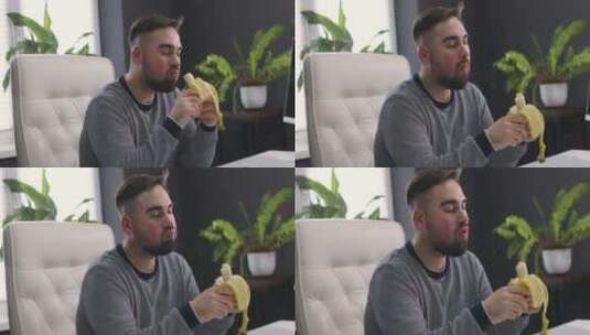 坐在办公桌前吃香蕉的男人高清在线视频素材下载