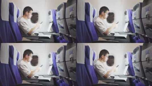 男子在飞机上用手机刷视频高清在线视频素材下载