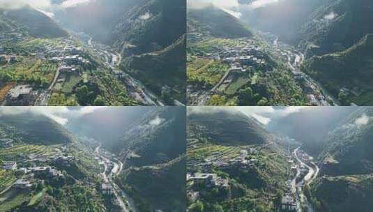 航拍高山之间的峡谷，溪流旁边是村庄电线杆高清在线视频素材下载