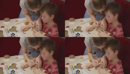 老师在粘土或陶艺工作坊中与男孩互动高清在线视频素材下载