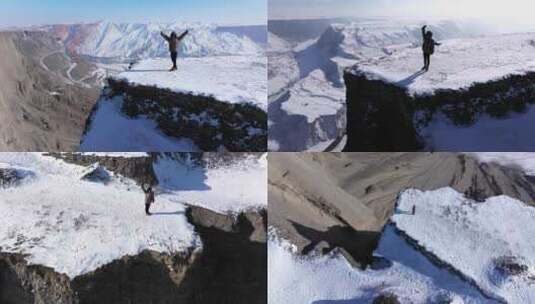 航拍女孩在冬季新疆安集海大峡谷悬崖边玩耍高清在线视频素材下载