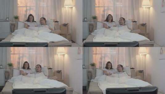 一对情侣坐躺床上看电影高清在线视频素材下载