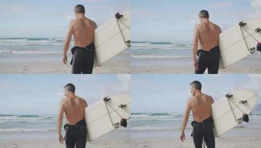 海滩上拿着冲浪板的男人高清在线视频素材下载