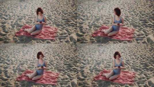 穿着泳衣的女人在海滩玩电子游戏高清在线视频素材下载