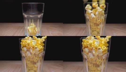 木质桌子上一只装满爆米花的玻璃杯高清在线视频素材下载
