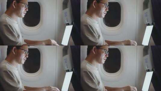 男子在飞机上使用笔记本电脑高清在线视频素材下载