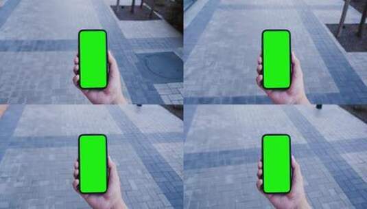 手拿绿幕手机在街上行走导航高清在线视频素材下载