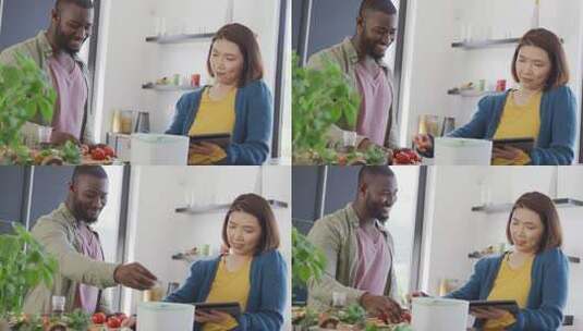 快乐的多样化夫妇在厨房准备食物、使用平板电脑和堆肥蔬菜的视频高清在线视频素材下载