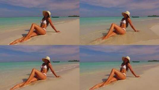美丽的美女模特在天堂白沙和蓝色背景的海滩上晒太阳旅行高清在线视频素材下载