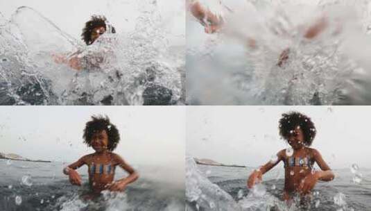 儿童站在海水里对着镜头用手泼水高清在线视频素材下载