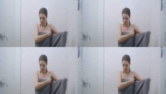 站在淋浴间用毛巾裹着身体的女人高清在线视频素材下载
