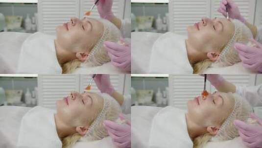 美容师给美女脸上涂抹面霜高清在线视频素材下载