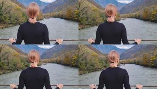 女人站在桥上看着河流和山脉高清在线视频素材下载