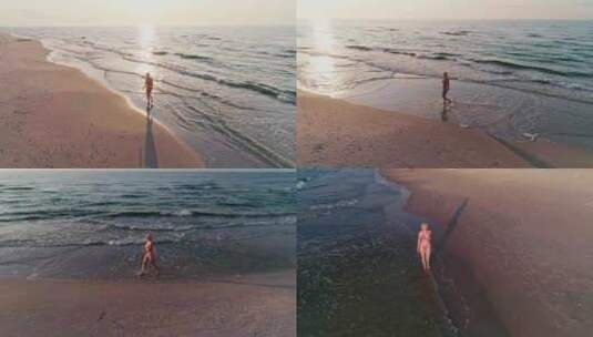 空中：自信的年轻女子在美丽的日落灯光下漫步在海滩上，海浪拍打着头高清在线视频素材下载