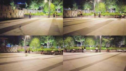夜晚公园广场玩滑板车的年轻人高清在线视频素材下载