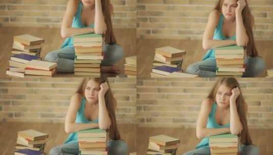 女孩看着地板上 堆叠的书籍苦笑 高清在线视频素材下载