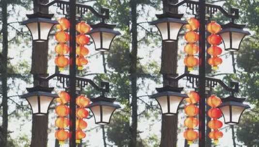 清晨公园路灯杆上橘黄色新年灯笼在风中摆动高清在线视频素材下载