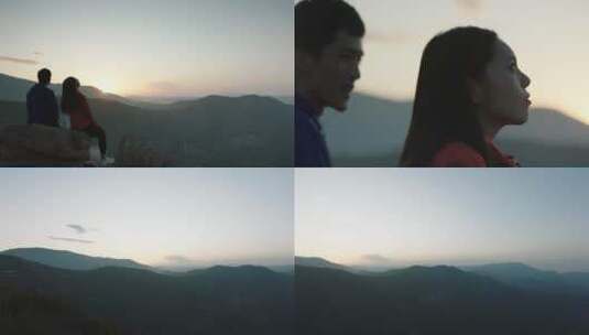 情侣在山顶大石头上看夕阳高清在线视频素材下载