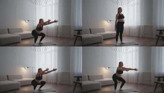 怀孕的女运动员保持做运动在怀孕蹲在客厅家高清在线视频素材下载