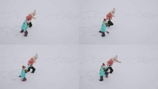 在厚厚的雪地里行走的母女高清在线视频素材下载