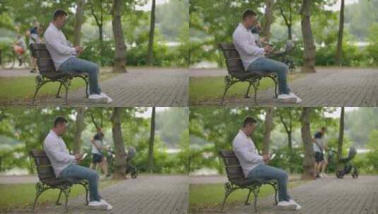 坐在公园长椅上玩手机的男人高清在线视频素材下载