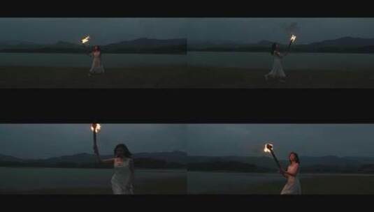 白色长裙女子举着火把走在草地上高清在线视频素材下载