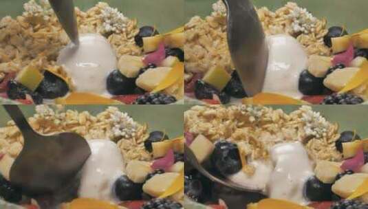 用勺子舀着酸奶和时令水果的混合物高清在线视频素材下载