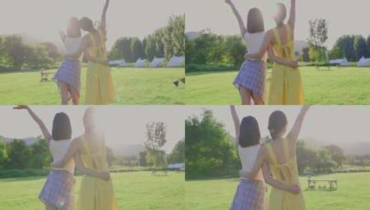 两个美女在露营地的绿色草地上拥抱阳光高清在线视频素材下载