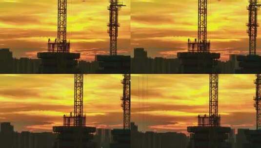 夕阳下塔吊作业工人施工剪影航拍高清在线视频素材下载