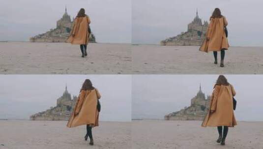 后视镜放大在史诗圣米歇尔山的海沙上缓慢行走的时尚旅游女性高清在线视频素材下载