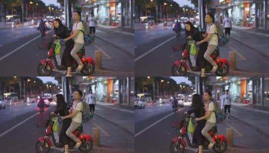 街上情侣骑一辆共享电动车高清在线视频素材下载