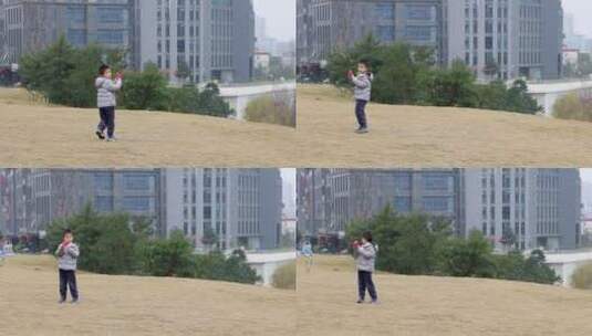 小男孩在城市公园草地上奔跑着放风筝高清在线视频素材下载