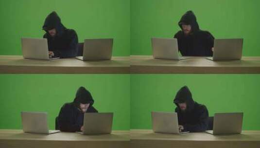 无法辨认的男子黑客穿着运动衫兜帽，在2台笔记本电脑上打字高清在线视频素材下载