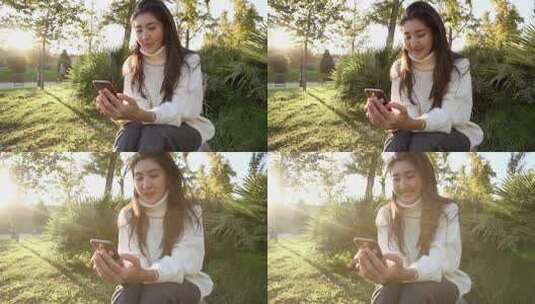 年轻的女性在草地上玩手机高清在线视频素材下载