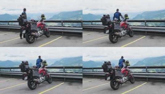 骑着带行李袋的旅游摩托车的自行车手站在山景阿尔卑斯山旁高清在线视频素材下载